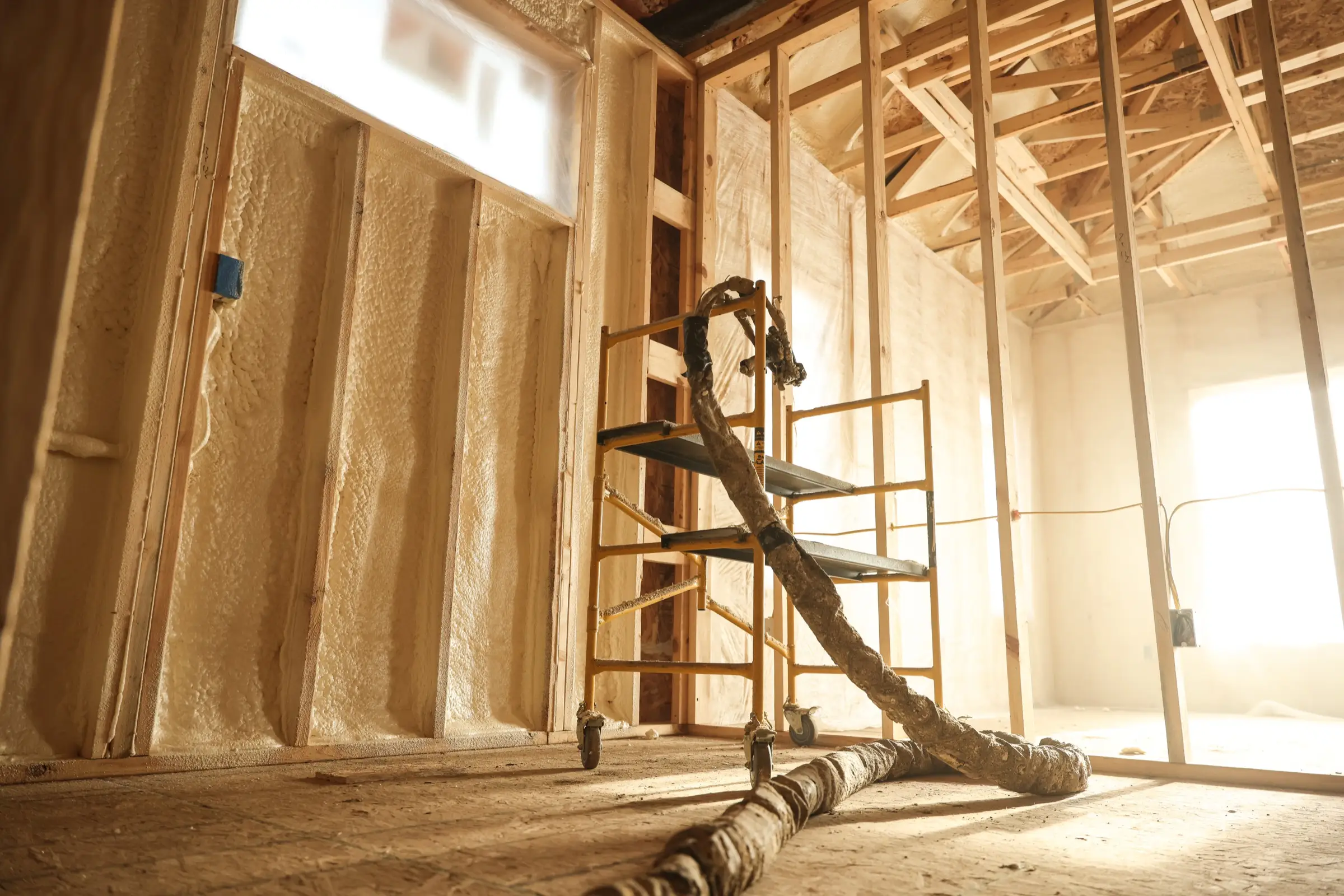 Installer applying spray foam insulation with professional equipment